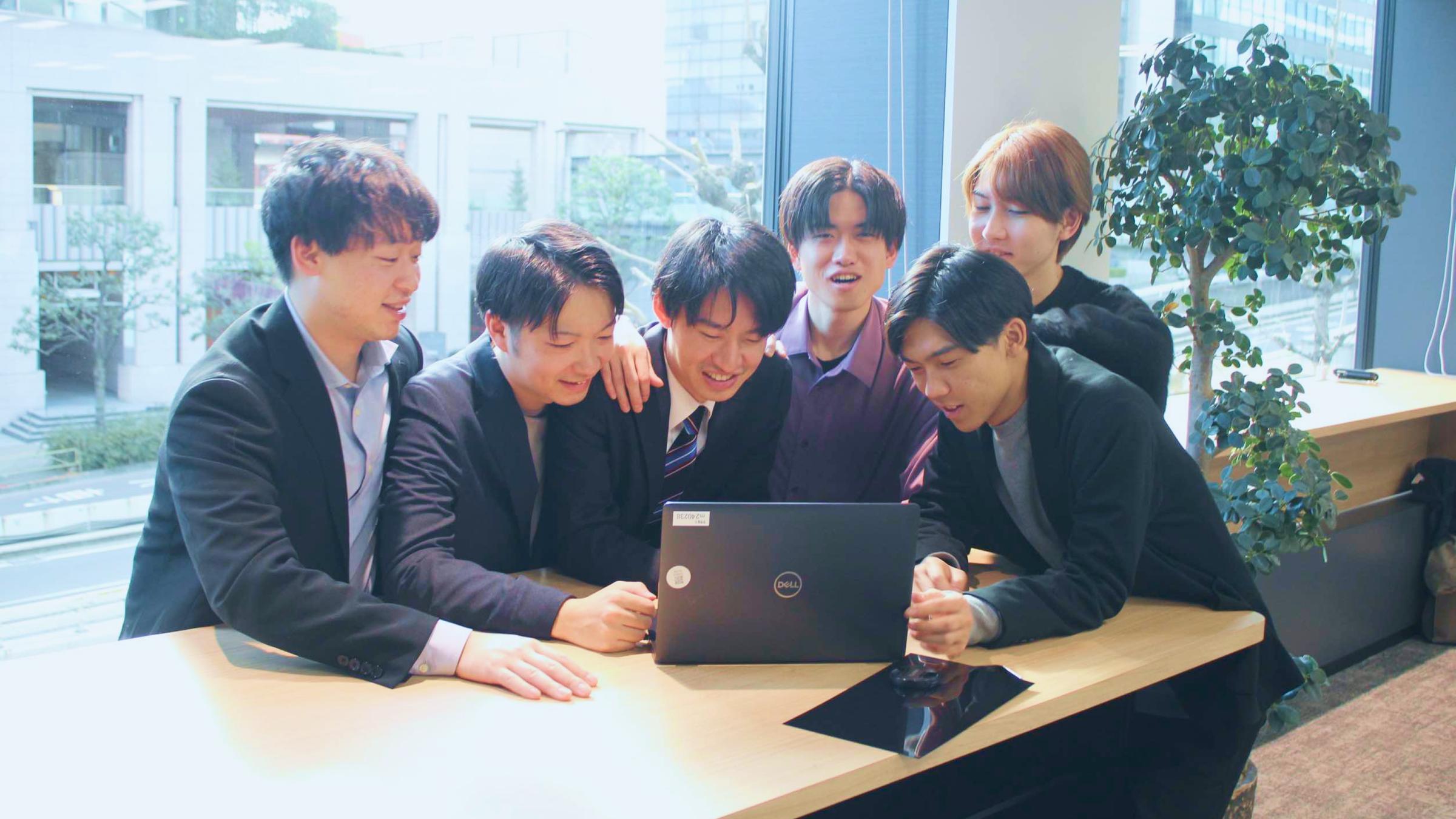 1台のノートPCの画面をのぞき込むRezonのメンバー6人。渋谷オフィスにて